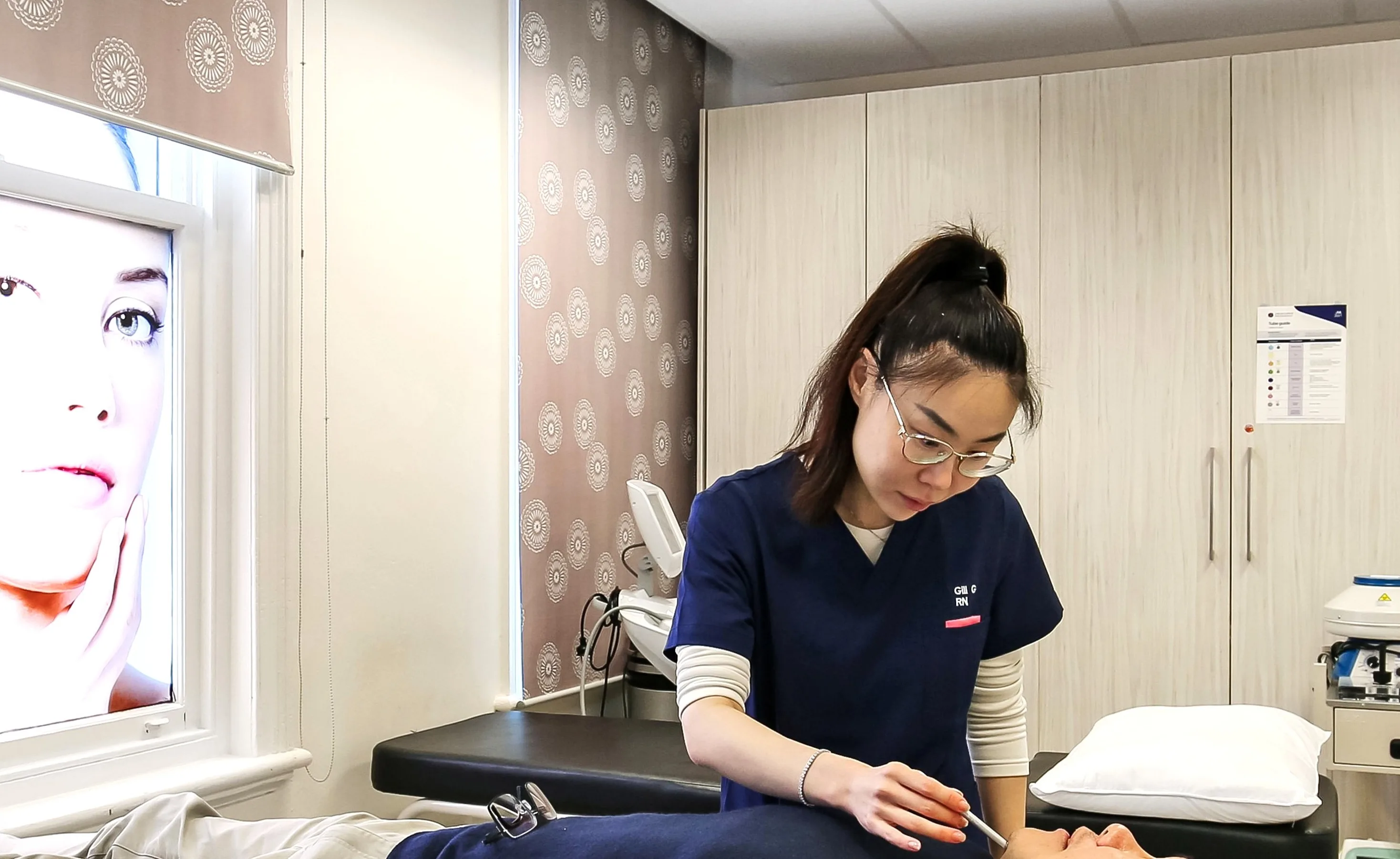 Clinician in navy scrubs performing a facial treatment at HEMAC